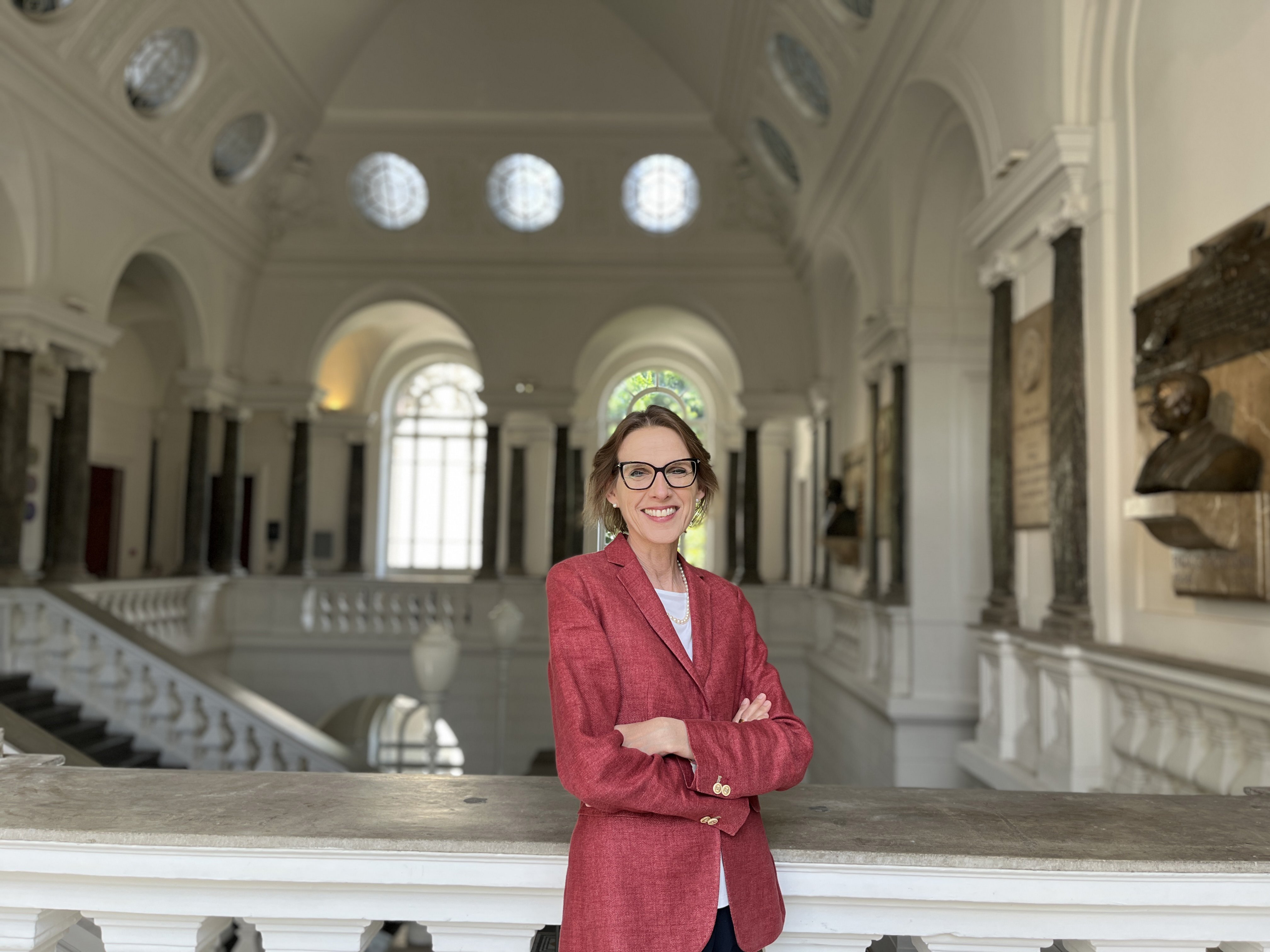 Donna di mezza età con le braccia conserte, sorridente e i capelli legati